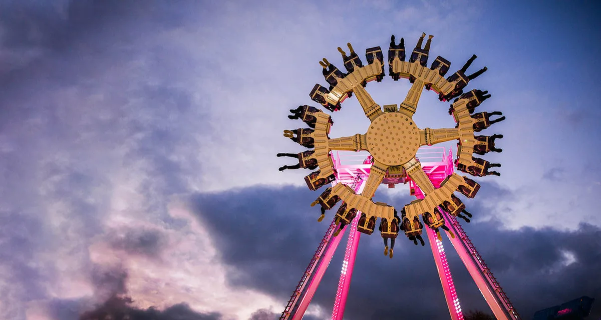 The Axis ride at Adventure Island illuminated against a cloudy sky