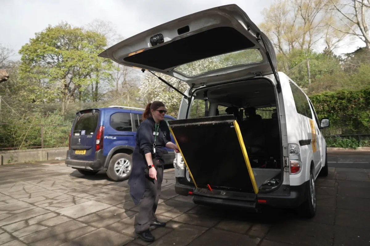 An Edinburgh Zoo staff member lowering the wheelchair ramp on the zoo's mobility vehicle