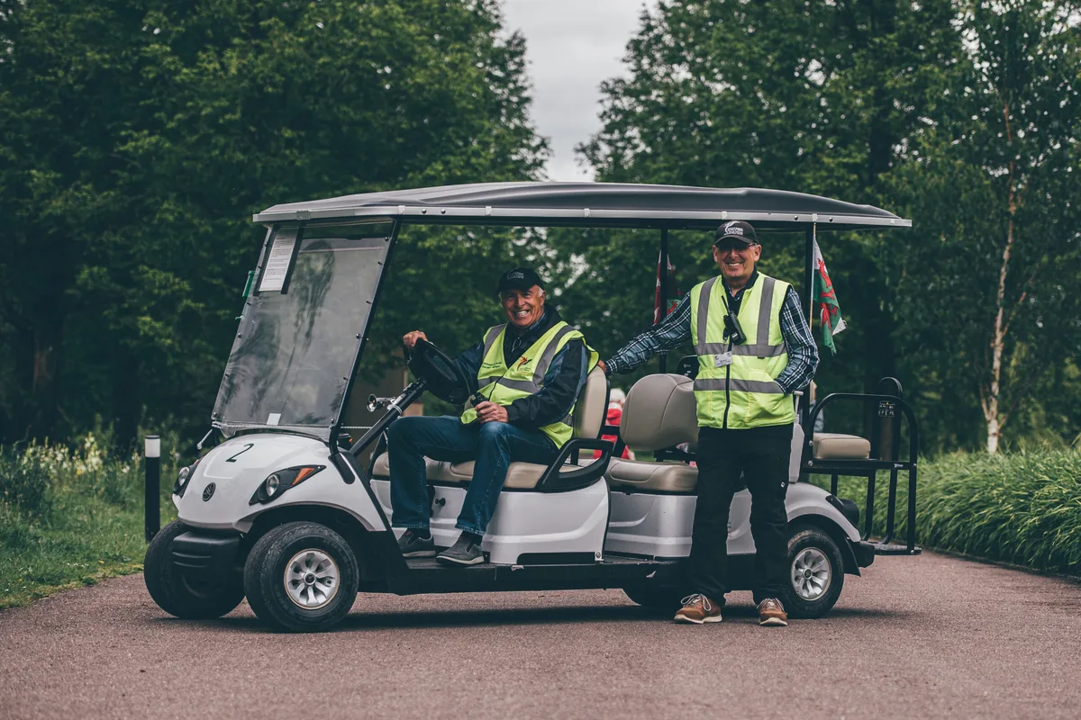Two National Botanic Garden of Wales volunteers beside the accessible visitor shuttle buggy