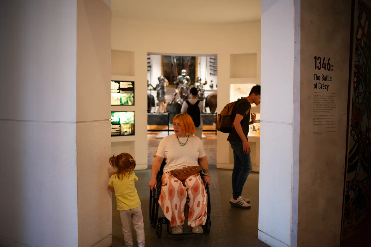 A wheelchair user moving through a spacious gallery at the Royal Armouries Museum